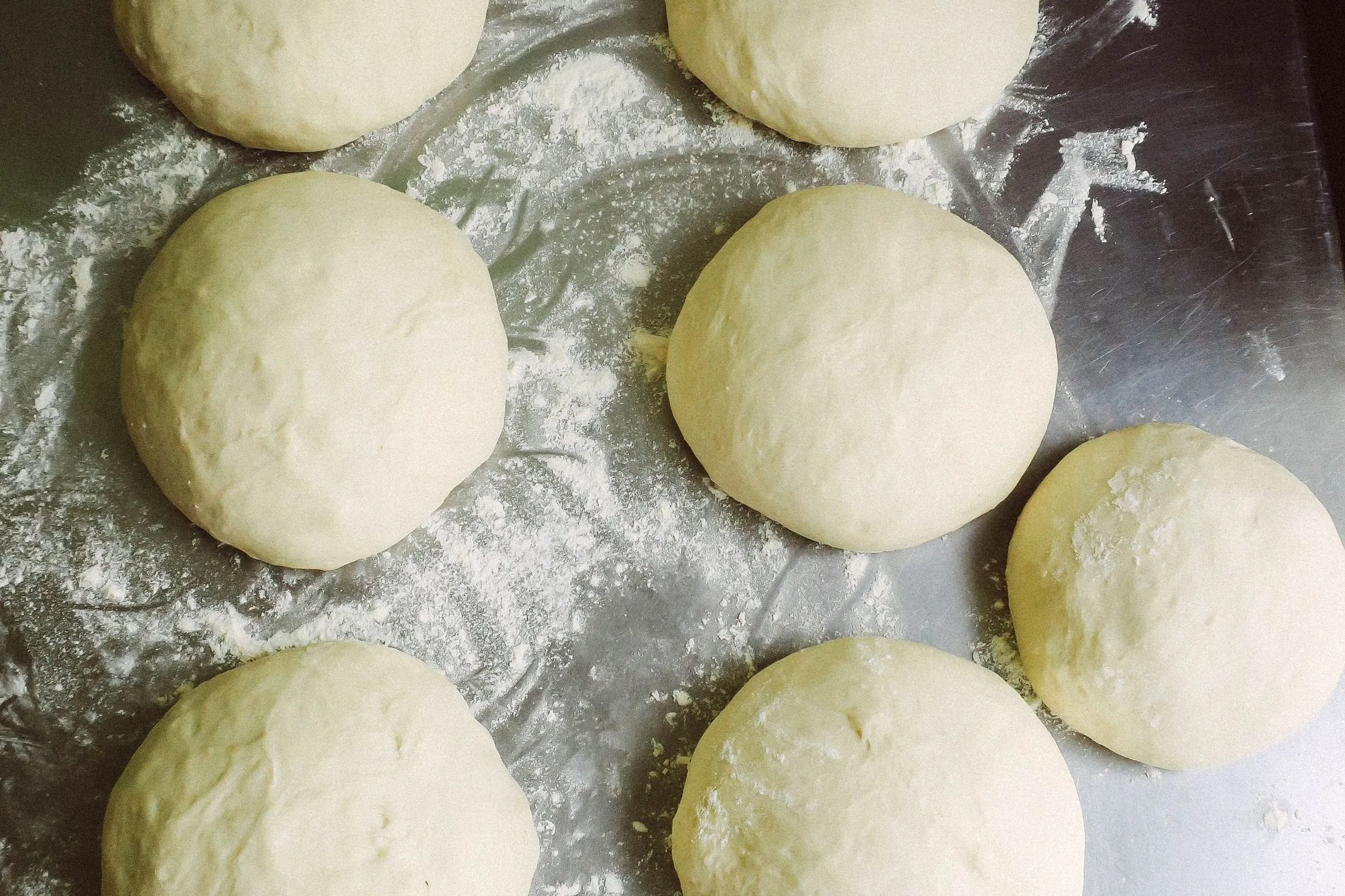 Pâtons de pâte à pizza sur un plan de travail fariné